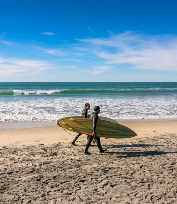 Tijuana surfers in wetsuits at beach 