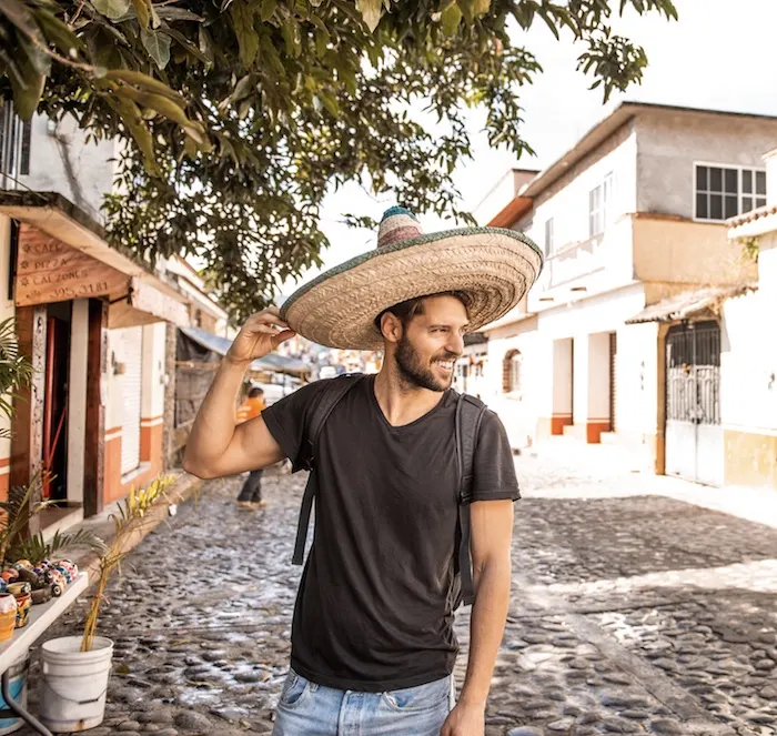 Smiling caucasian tourist wearing sombrero in streets of Cancun