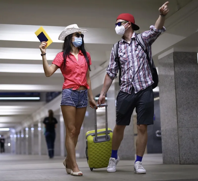 couple masks heading for vacation airport