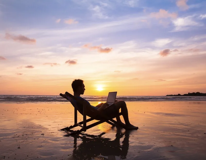 digital nomad working from the beach