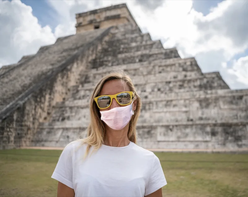 tourist in face mask at Mayan pyramid Chichen Itza, Mexico
