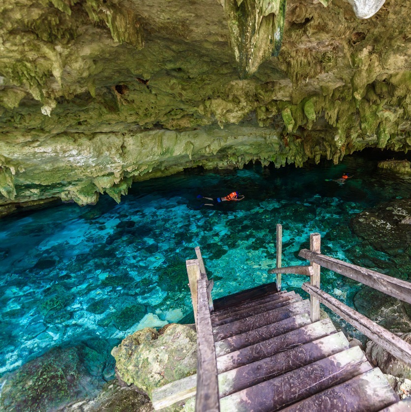 Cenote Dos Ojos in Quintana Roo, Mexico. People swimming and snorkeling in clear water. This cenote is located close to Tulum in Yucatan peninsula, Mexico. (Cenote Dos Ojos in Quintana Roo, Mexico. People swimming and snorkeling in clear water.