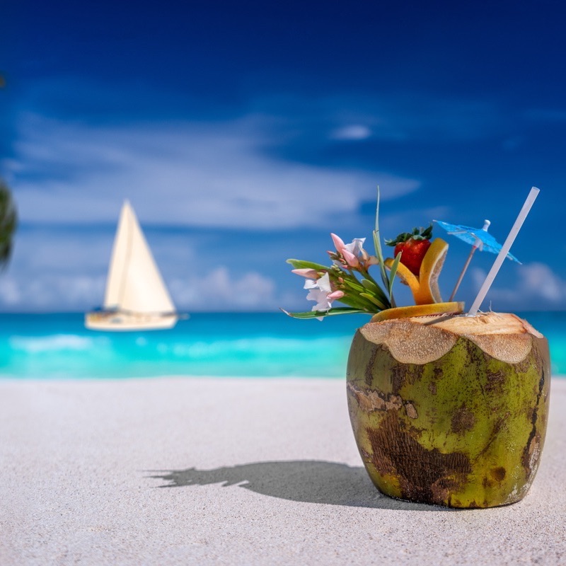 close up image of a coconut drink on a tropical beach in the Riviera Maya.