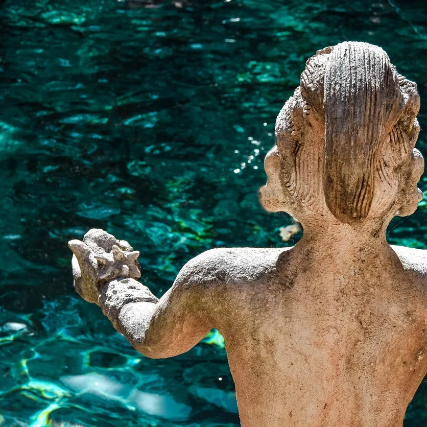 Statue in Zacil-Ha Cenote, Quintana Roo, Mexico.  Mayan statue that protects the crystal clear waters of the Zacil-Ha cenote. Zacil-Ha Cenote located in the state of Quintana Roo.