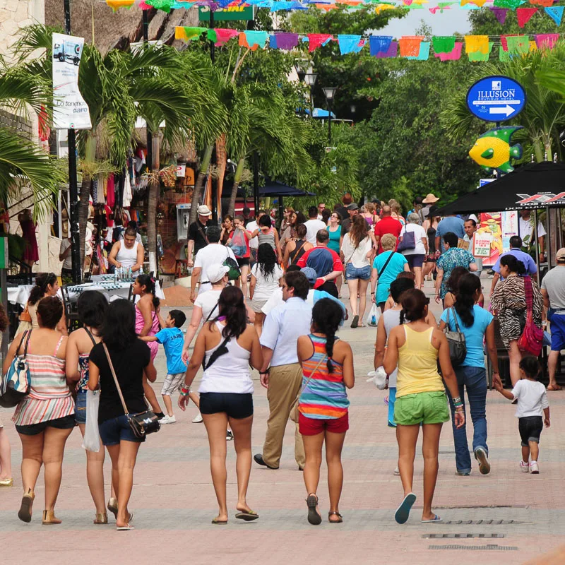 Tourists walking down a busy street in Cancun, Mexico.