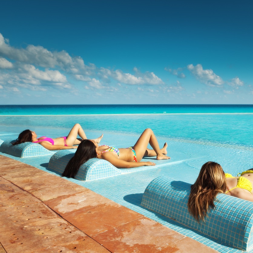Young women relaxing at a pool in Cancun, Mexico during spring break.