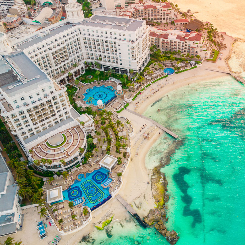 Cancun resort property with a sandy beach and beautiful turquoise water.