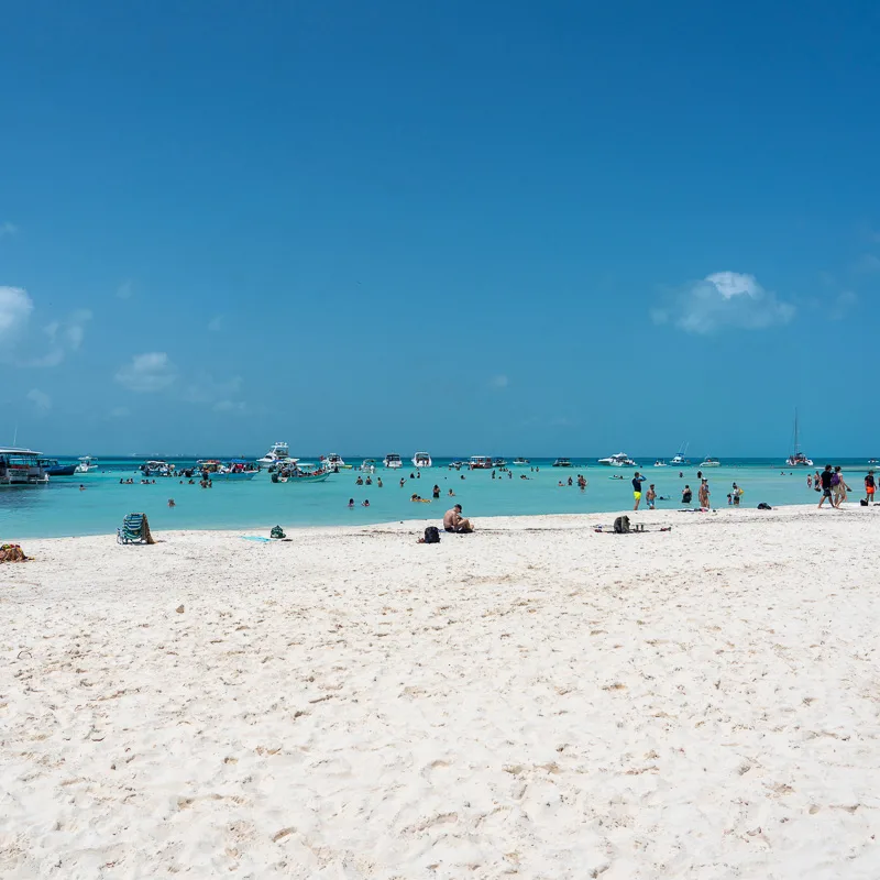 White sand Playa Norte beach in Isla Mujeres filled with tourists.