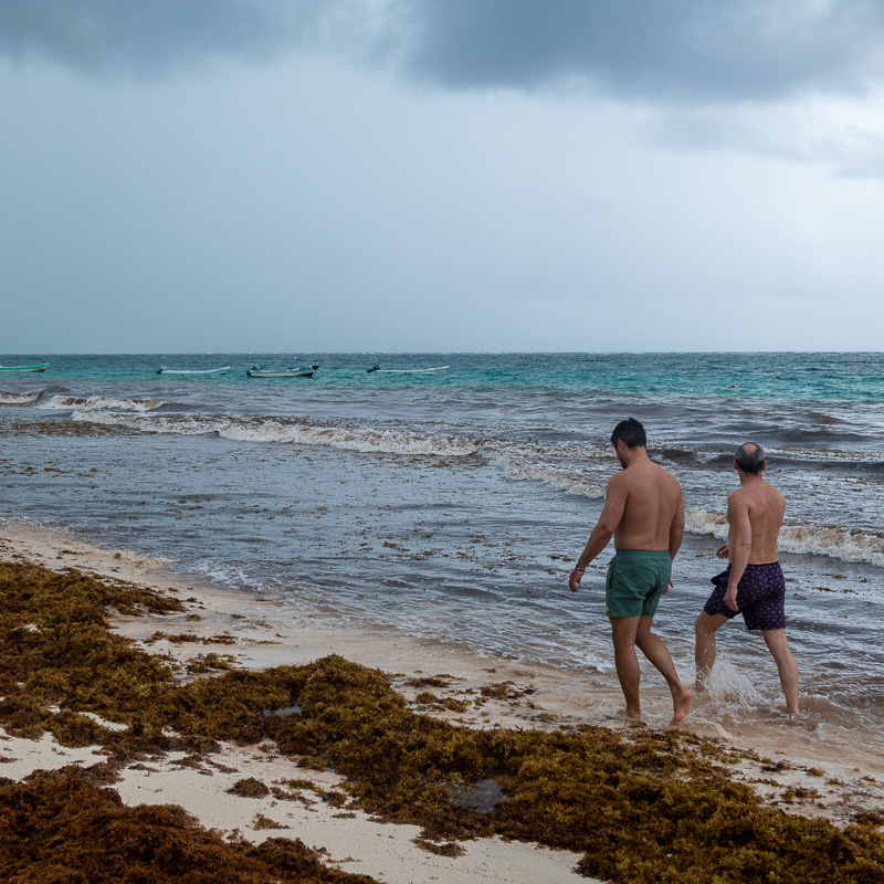 Men walking on a beach with cloudy weather 