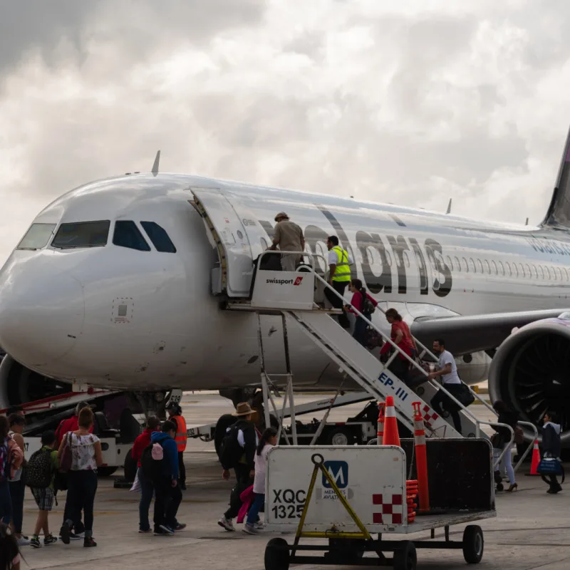 A Volaris flight on the tarmac at an airport boarding passnegers