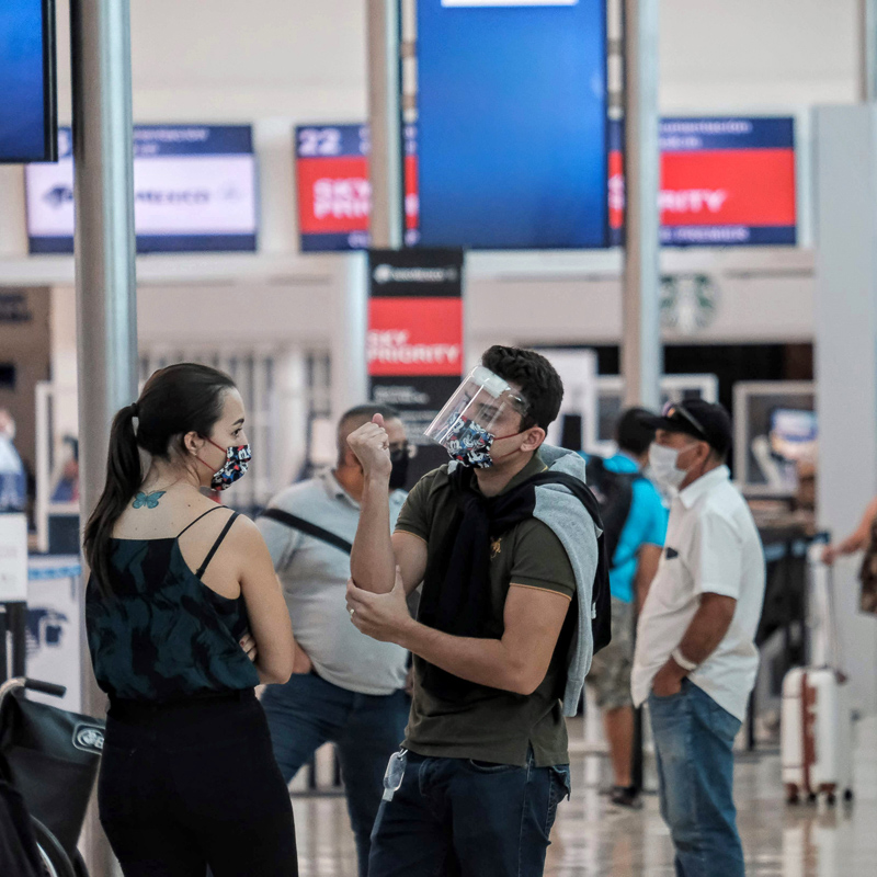 two people in airport wearing masks