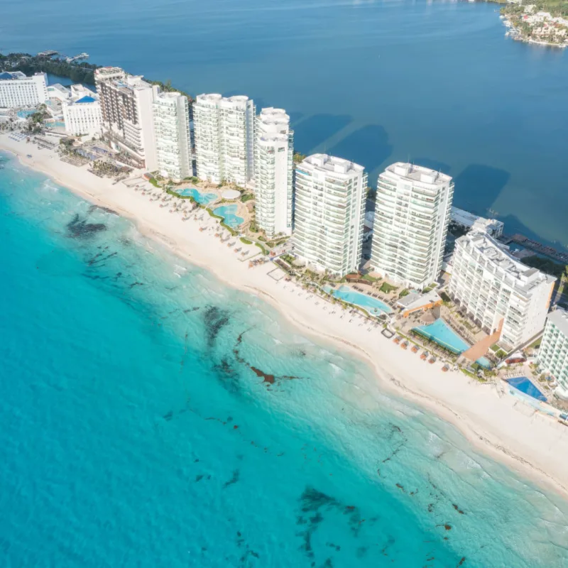 Cancun Hotel Zone lined with luxury resorts and surrounded by aqua blue water and white sand beaches.