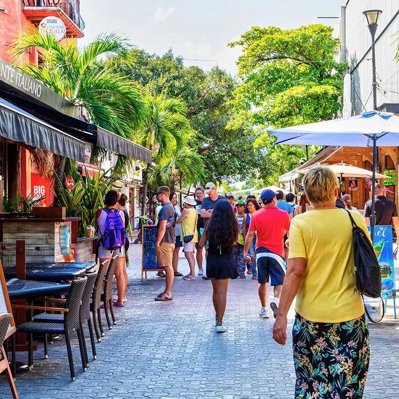 tourists walking along Playa del Carmen's Fifth Avenue during the day