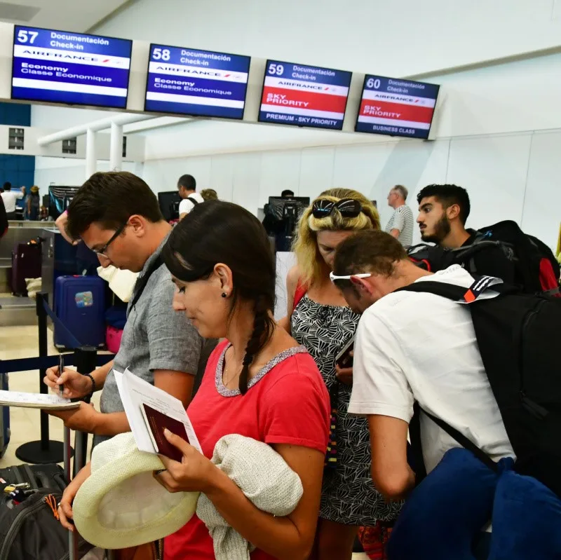 Tourist on the phone waiting at Cancun Airport.