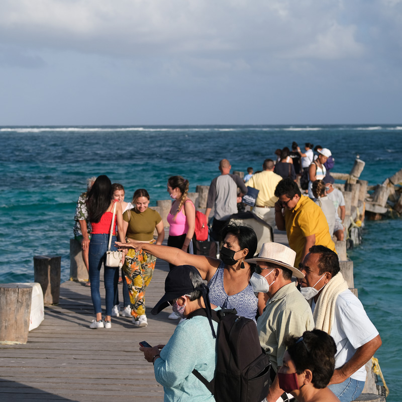 tourists on dock with masks