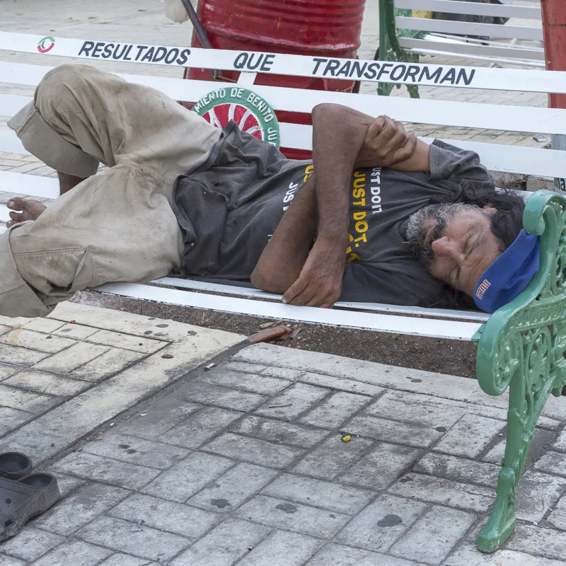 homeless man on bench in cancun