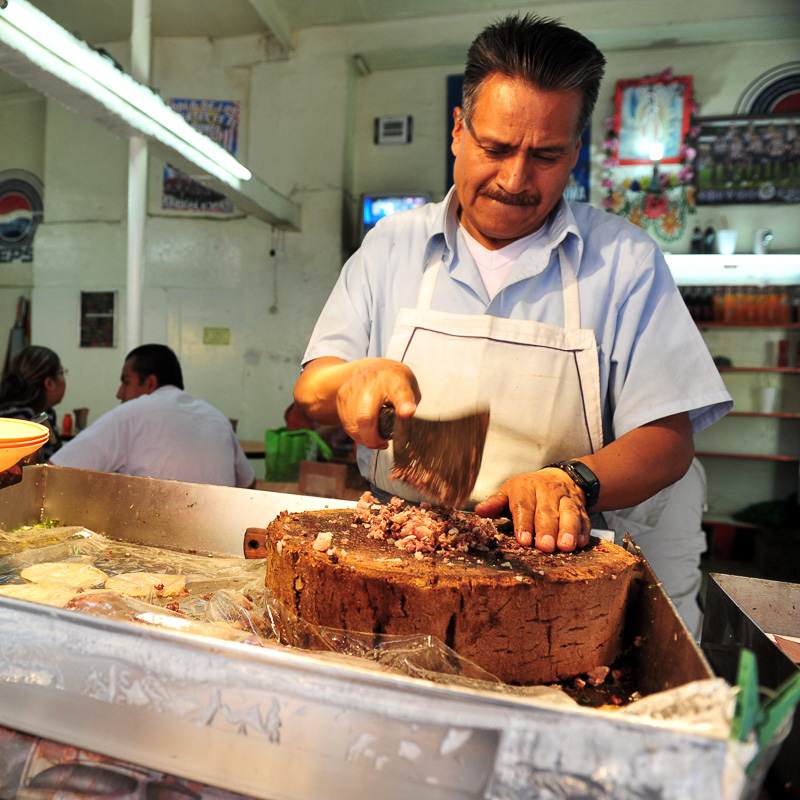 man cutting meat for tacos