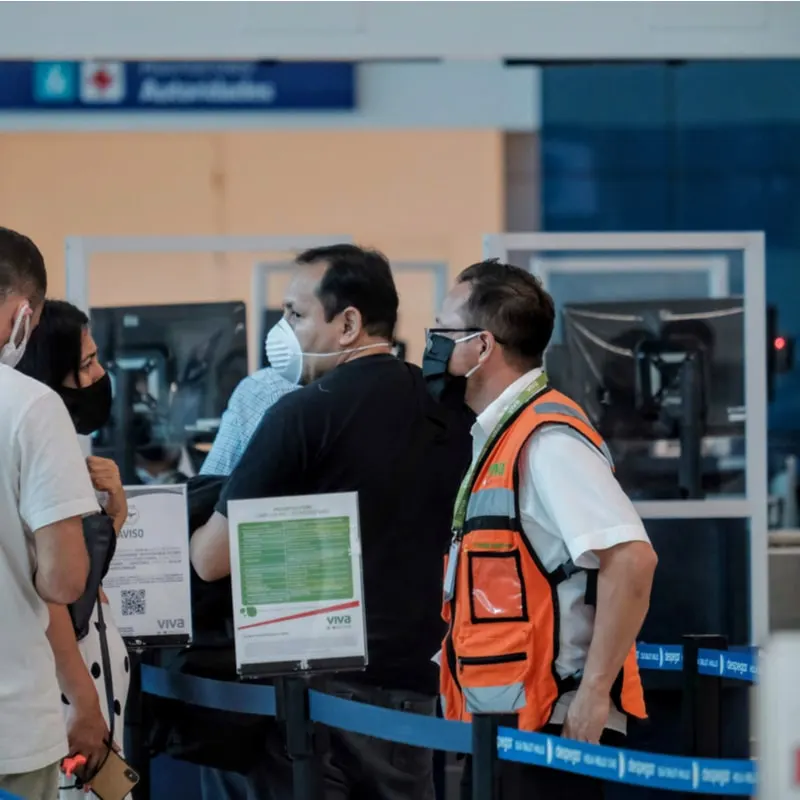 Tourist And Employee In Mask In Airport