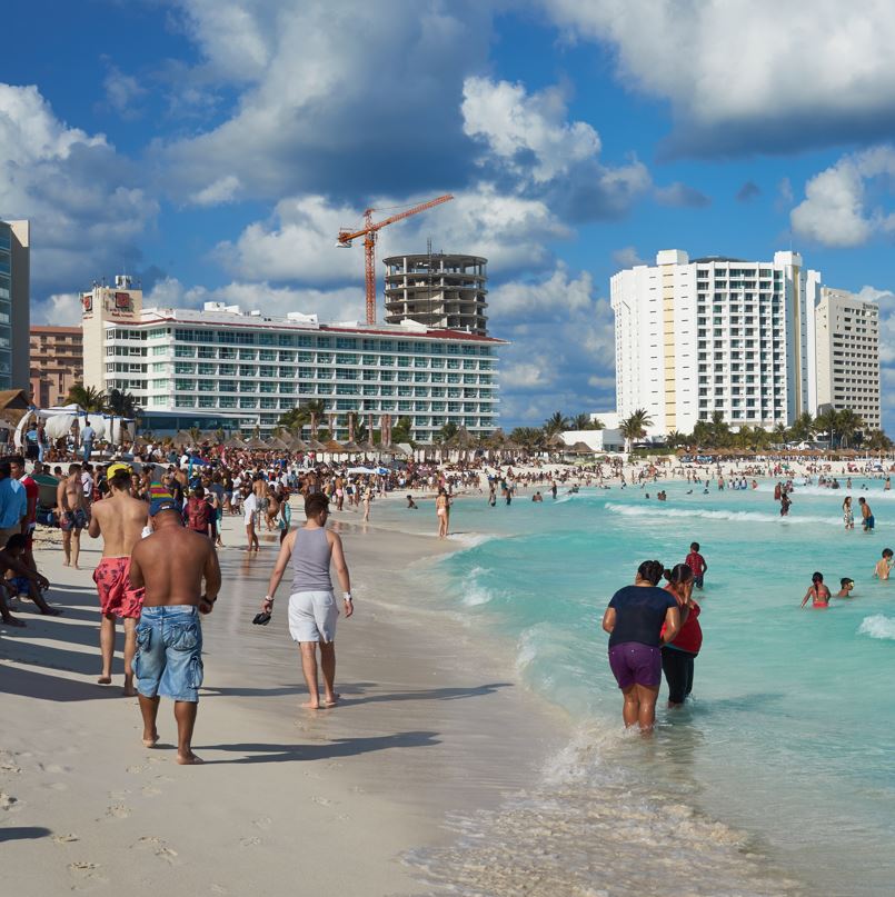 Cancun tourists on beach near hotel zone