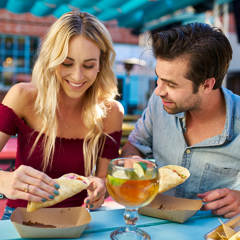 Couple eating Mexican food in Cancun alongside refreshing drink