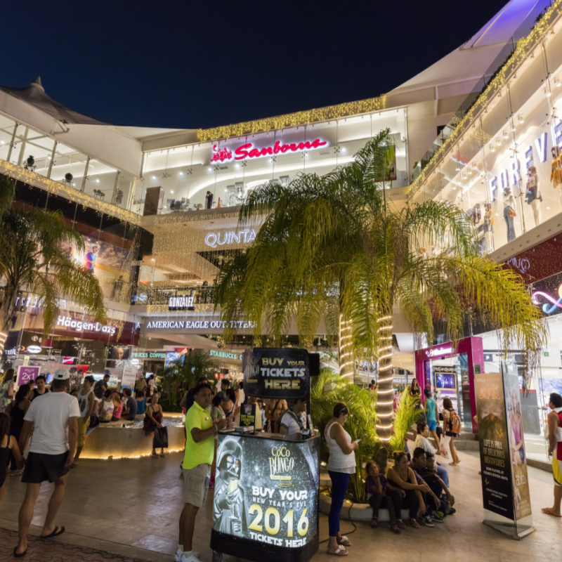 Playa del Carmen shopping with people everywhere and advertisements for nightclubs.