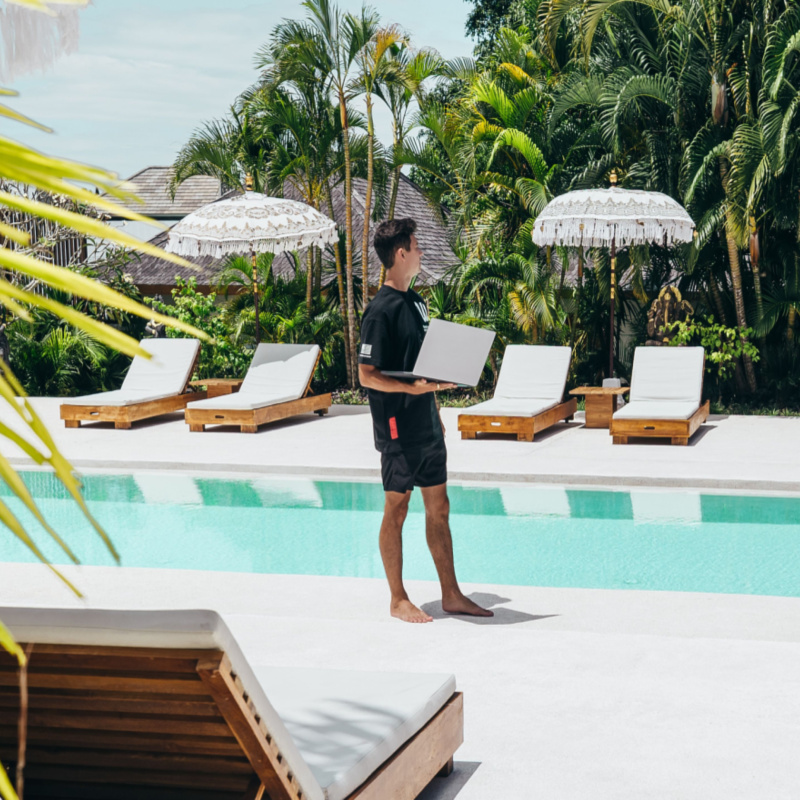 mand by pool with laptop