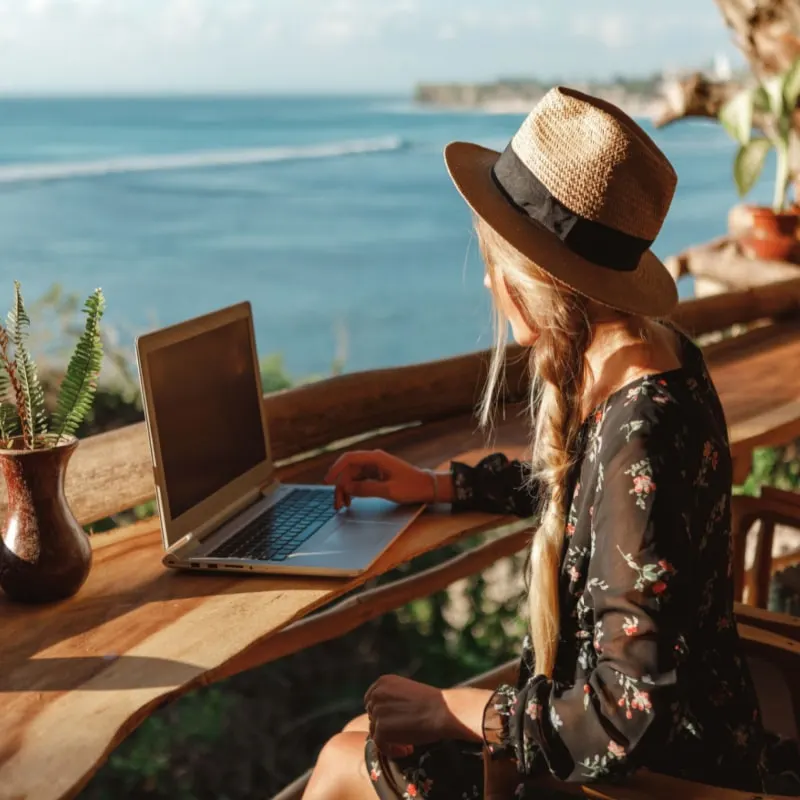 woman using laptop looking at the beach