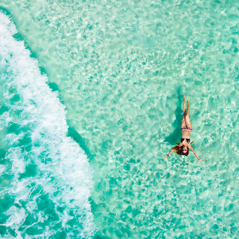 Woman swimming in turquoise water in Mexican Caribbean