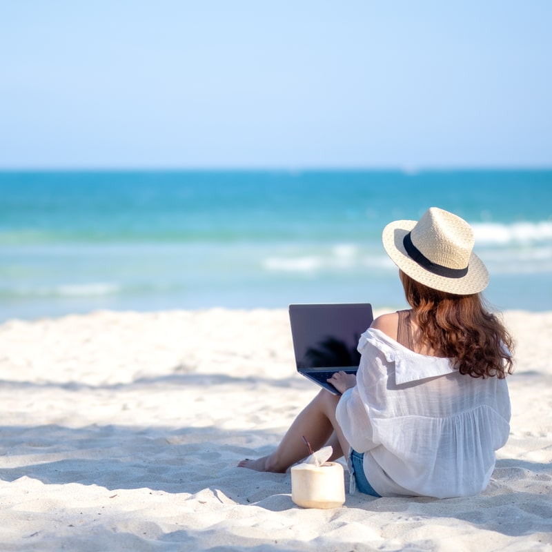 woman using notebook at the beach