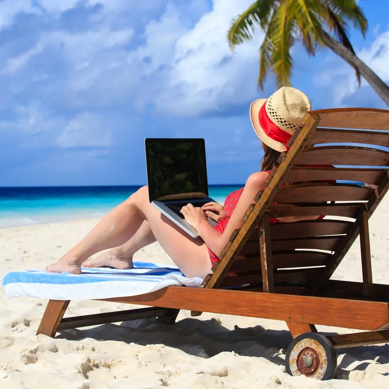 woman using notebook on the beach