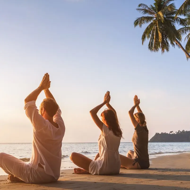 people doing yoga on beach