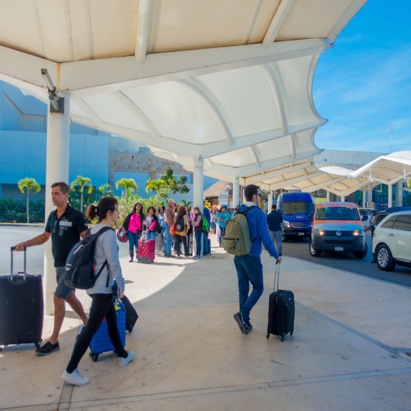 Tourists walking around the road transport pick up area at cancun airport