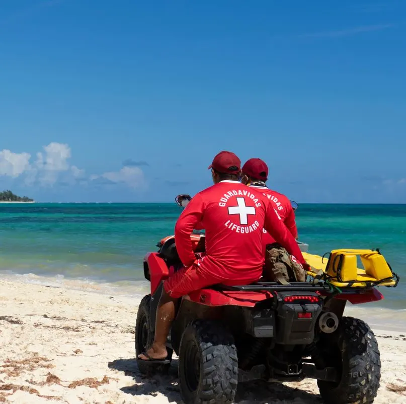 Lifeguards on Tulum Beach patrolling the beach on an ATV.