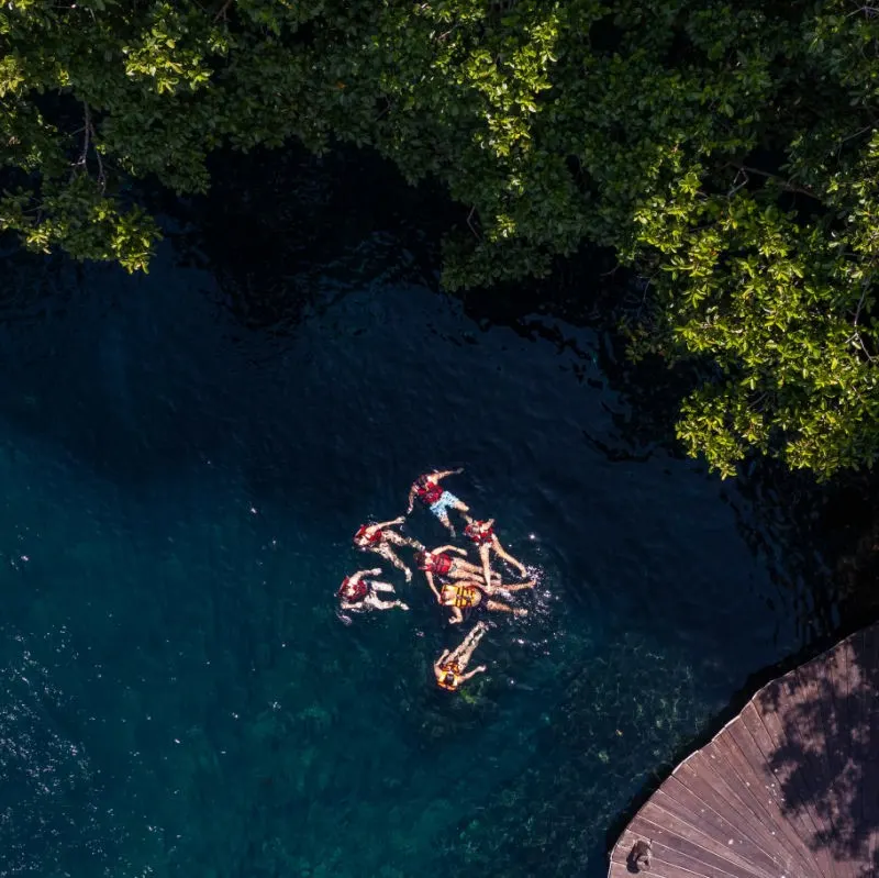 aerial view of tourists swimming in a cenote.
