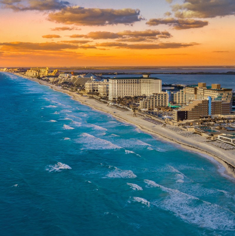bird's eye view of Cancun hotel zone by the coastline at sunset
