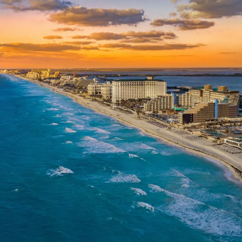 bird's eye view of Cancun hotel zone by the coastline at sunset