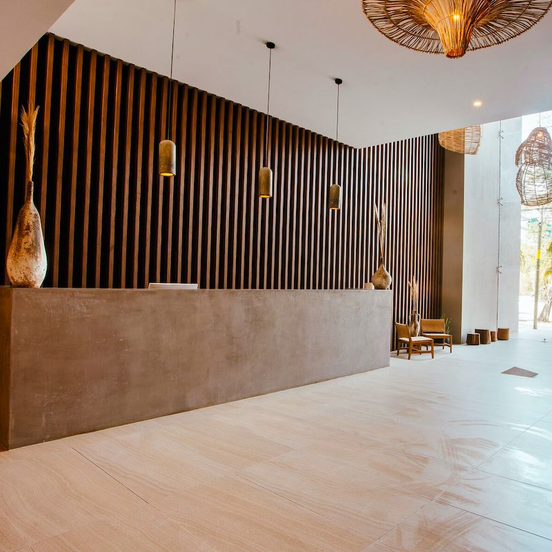 reception area of Selina in downtown Tulum, wide beige floor and wood background