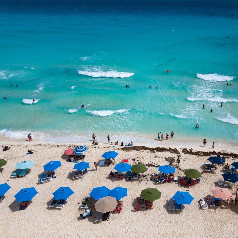 aerial view of umbrellas and tourists in the sun on a typical beach in Cancun