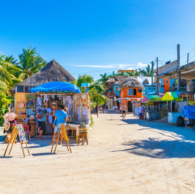 little shops on a street in Holbox, sunny day and colorful pastel buildings