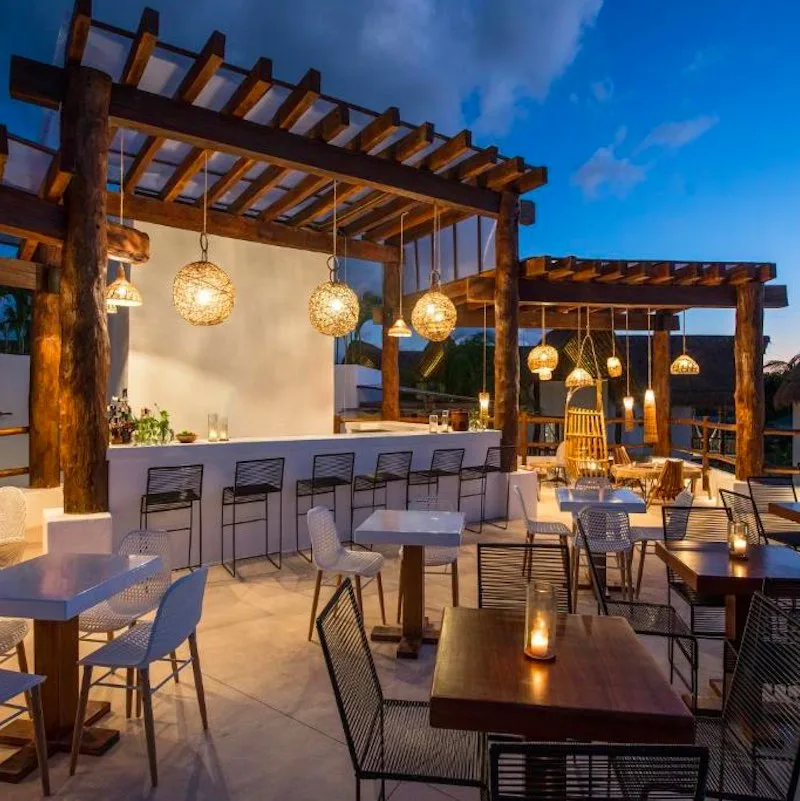 Villas HM Palapas del Mar hotel with all-inclusive option in Holbox. Outdoor dining area lit up in the evening
