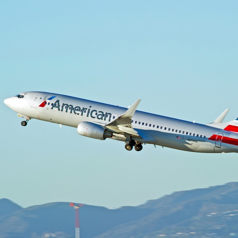 american airlines aircraft taking off from airport, Los Angeles in the background