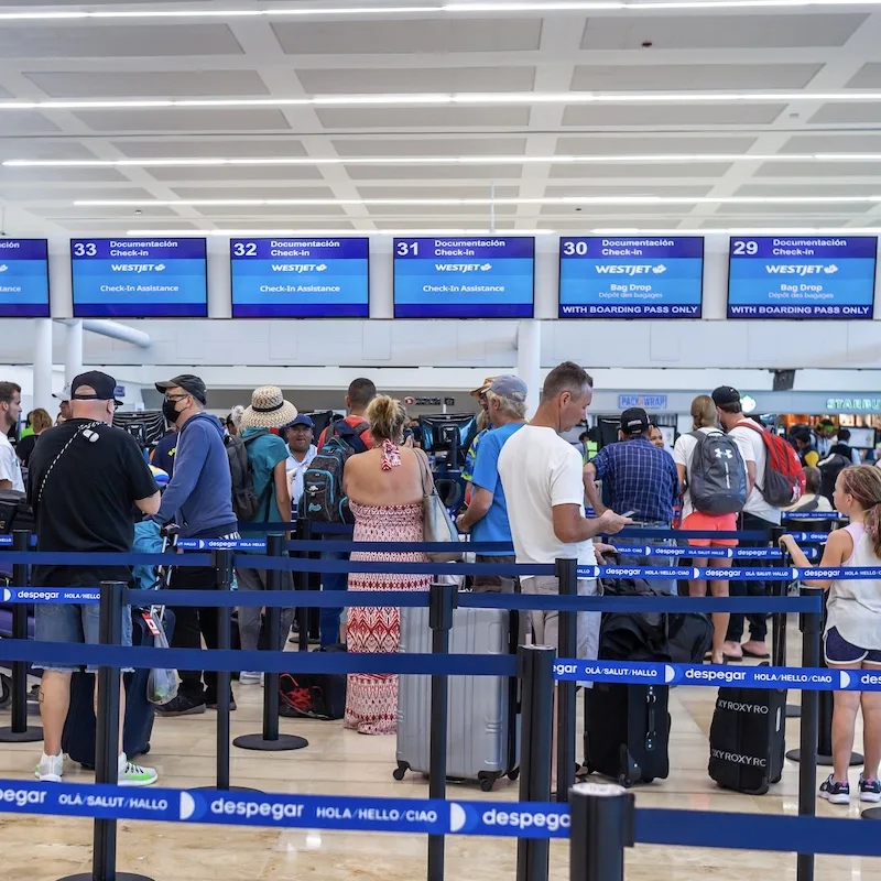 Busy Cancun airport check in with people standing in line waiting.