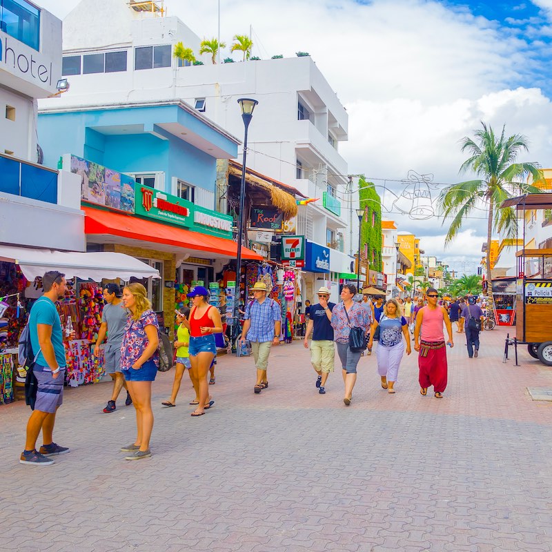 Crowd of tourists along 5th avenue in Playa del Carmen during the day.