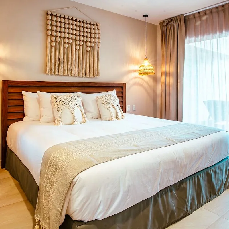 bed with white sheets and accents on wall at Selina Tulum downtown property. private standard room.