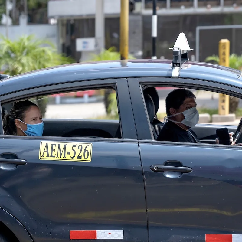 Passengers inside a local taxi with the windows rolled down