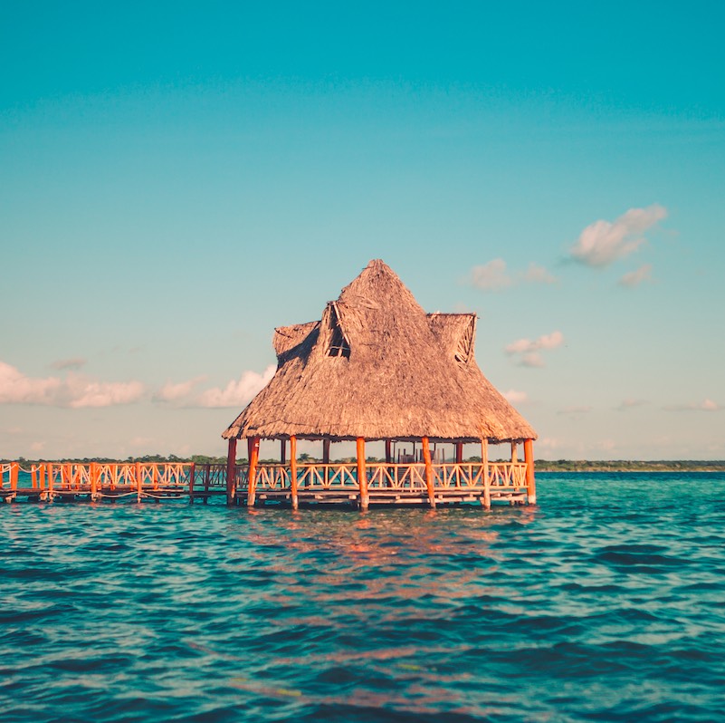 Color graded picture of a pier with clouds and blue water at the Laguna Bacalar, Chetumal, Quintana Roo, Mexico.