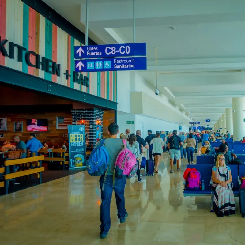 traveler walking in the terminal at Cancun International Airport.