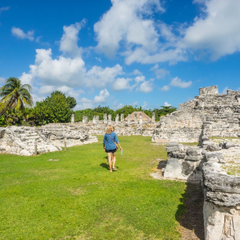 traveler walking through a tourist attraction, Mayan ruins in Yucatan Mexico. Sunny day.