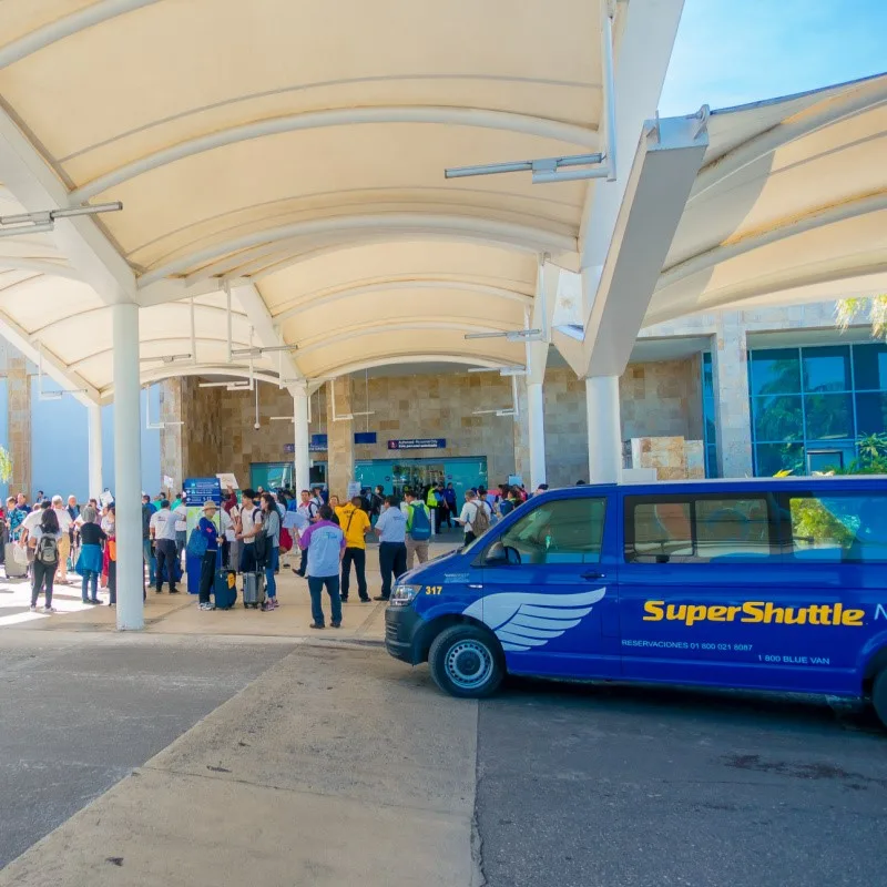 Cancun Shuttle Area with people and shuttles around.