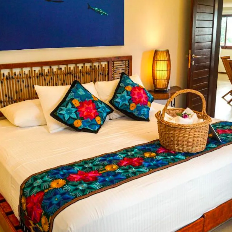room at Casa Azul Maya with Mexican-inspired decor, basket on bed.